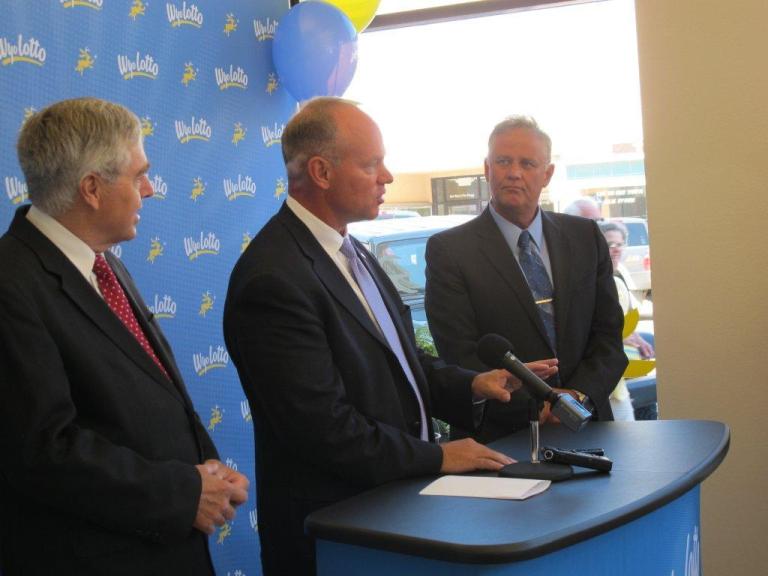 Gov. Matt Mead, flanked by Secretary of State Max Maxfield on the left, and Wyoming Lottery CEO Jon Clontz, on the right, addresses a news conference Monday, Aug. 18, 2014, to announce the winner of a promotional contest for the new state lottery, which begins selling Powerball and Mega Millions tickets statewide next Sunday. Mary Ogg, of Sheridan, won the contest to purchase the first lottery ticket to be sold in Wyoming. (AP Photo by Bob Moen).