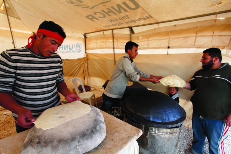 Syrian refugees bake bread at their tent bakery in Zaatari Syrian refugee camp, near the Syrian border in Mafraq, Jordan, Tuesday, Dec. 25, 2012. (AP Photo/Mohammad Hannon)