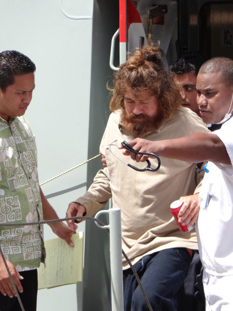 In this Feb. 3, 2014 photo, a man who identifies himself as Jose Salvador Alvarenga, center, gets off a ship in Majuro, the Marshall Islands, after he was rescued from being washed ashore on the tiny atoll of Ebon in the Pacific Ocean.  Alvarenga told the U.S. Ambassador in the Marshall Islands Tom Armbruster and the nation's officials that he left Mexico in December 2012 for a day of shark fishing and ended up surviving 13 months on fish, birds and turtles before washing ashore on the remote Marshall Islands thousands of miles (kilometers) away. (AP Photo/Marshall Island Journal) MARSHALL ISLANDS OUT