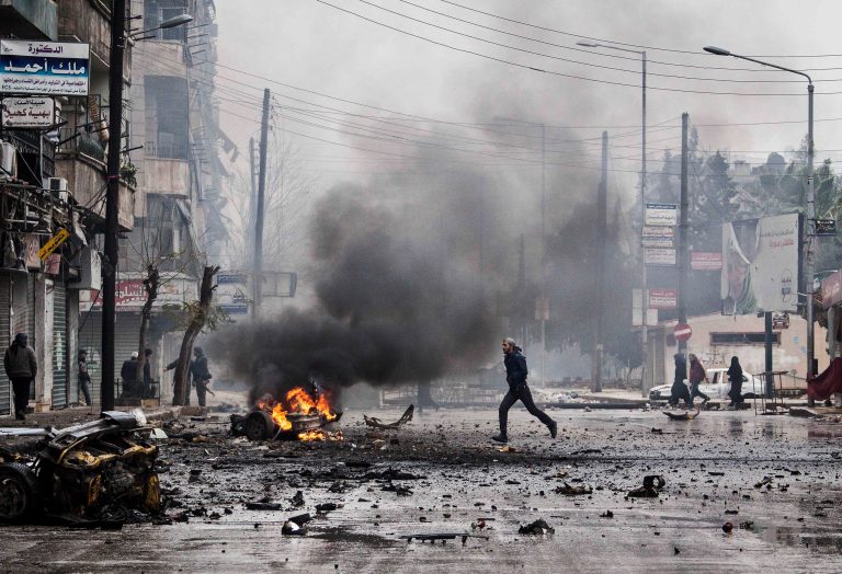   FILE - In this Dec. 17, 2012 file photo, a man runs between debris after a mortar shell hit a street killing several people in the Bustan Al-Qasr district of Aleppo, Syria. 2012 was a year of storms, of raging winds and rising waters, but also broader turbulence that strained our moorings. Old enmities and grievances resurfaced in the Middle East, clouding the legacy of the 2011 Arab spring. And the number of dead in the Syrian civil war passed 40,000. (AP Photo/Narciso Contreras, File)  
