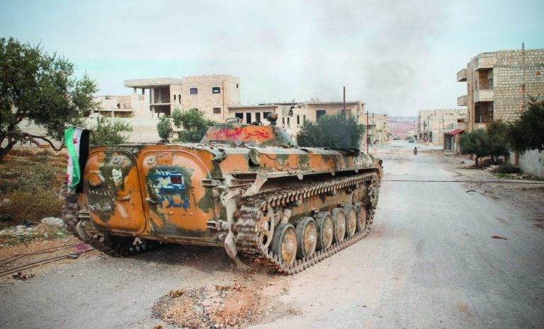 In this Saturday, Nov. 17, 2012 photo, an armored vehicle acquired from the Syrian army and flying the Syrian revolutionarily flag drives down a main street, in the northwestern city of Maraat al-Numan, Syria. After months of fierce fighting for control of the vital Aleppo-Damascus highway, rebels have succeeded in pushing the Syrian army out of the center of Maraat al-Numan located on the highway between Aleppo and Hama. (AP Photo/Mustafa Karali)