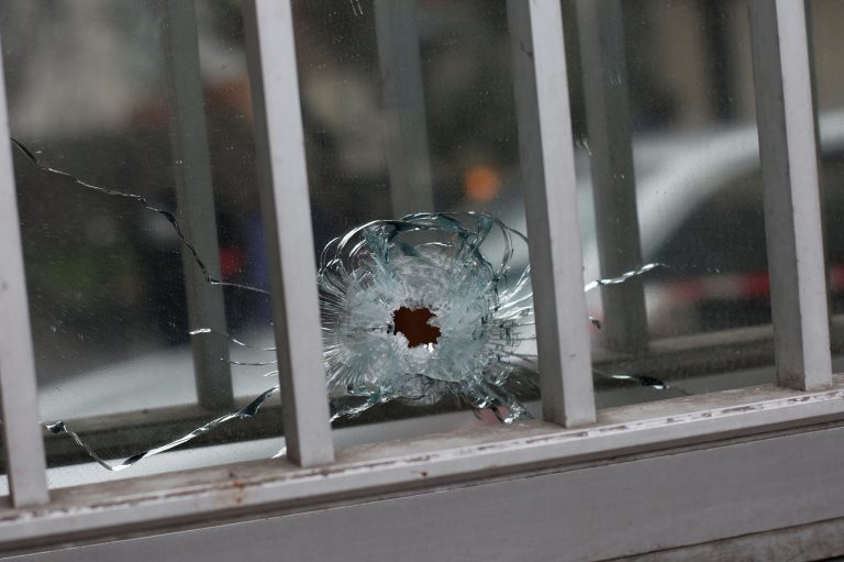 A bullet impact is seen in a window of a building next to the French satirical newspaper Charlie Hebdo's office, in Paris, Wednesday, Jan. 7, 2015. Masked gunmen shouting 