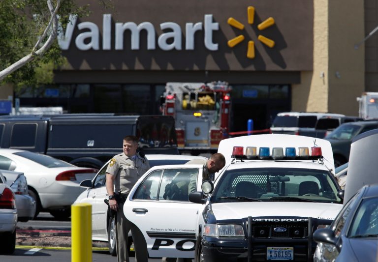 Las Vegas Metropolitan Police Department officers at the scene of a shooting Sunday, June 8, 2014 in Las Vegas. Police say two suspects shot two officers at a Las Vegas pizza parlor before fatally shooting a person and turning the guns on themselves at a nearby Walmart. (AP Photo/John Locher)