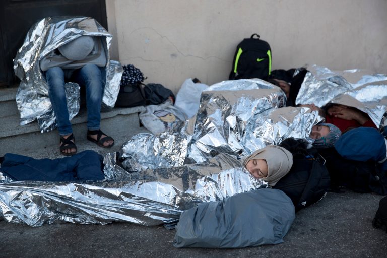 Syrian refugees wrapped with a thermal blanket sleep at the port of Mitylene on the northeast Greek island of Lesbos while waiting to get on board a ferry traveling to Athens.(AP Photo/Petros Giannakouris)