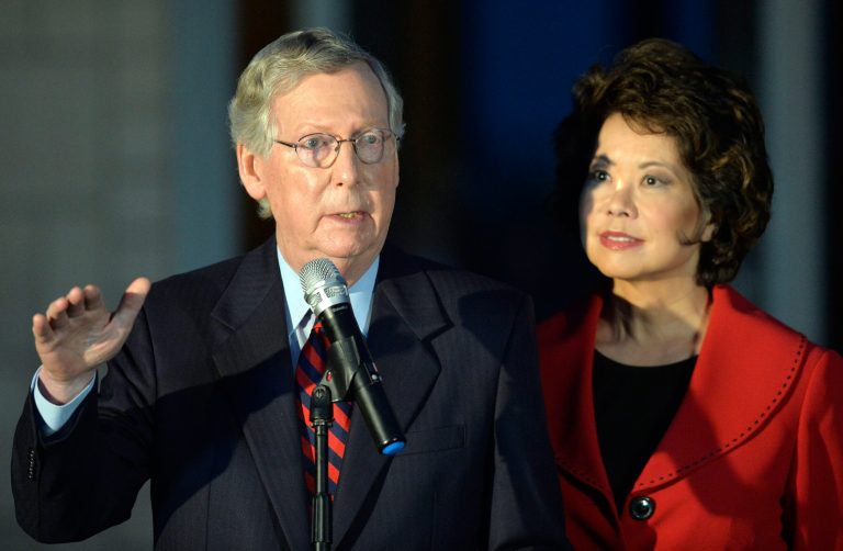 Kentucky Sen. Mitch McConnell, left, addresses the media as his wife Elaine Chao looks on Thursday, in Lexington, Ky. (AP Photo/Timothy D. Easley)