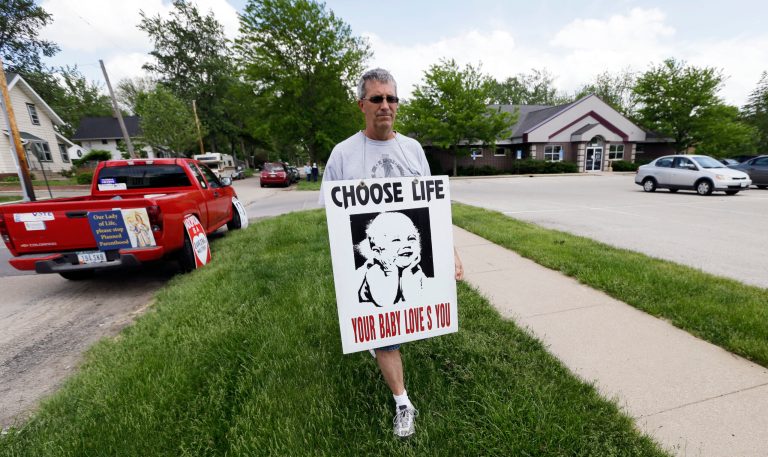 Coalition for Life of Iowa member Ron Digmann walks in front of the Planned Parenthood clinic, Tuesday, May 21, 2013, in Cedar Rapids, Iowa. (AP Photo)Â 