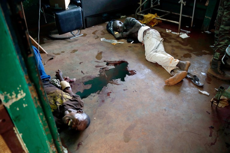 FILE - In this Thursday, Dec. 5, 2013 file photo, a young man screams in pain as he lies in a pool of blood on the floor of a hospital in Bangui, Central African Republic following a day-long gun battle between Seleka soldiers and Christian militias. A new U.N. report obtained Thursday, June 5, 2014 says 