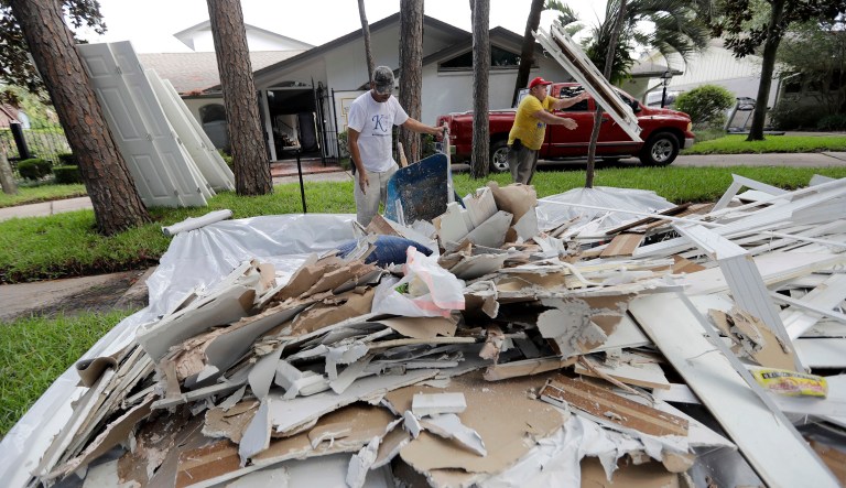 Jose Martinez, left, and William Majano remove drywall and baseboards from a home damaged by floodwaters from Tropical Storm Harvey on Wednesday, Aug. 30, 2017, in Houston. (AP Photo/David J. Phillip)
