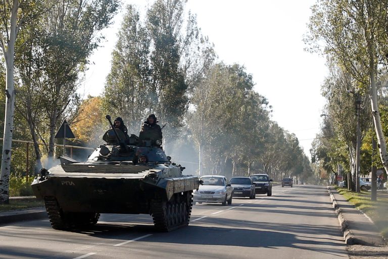 A pro-Russian  armored personal carrier passes through the town of Donetsk, eastern Ukraine, Thursday, Oct. 2, 2014. Pro-Russian rebels in eastern Ukraine advanced Wednesday on the government-held airport in Donetsk, pressing to seize the key transportation hub even as the two sides bargained over a troop pullout under a much-violated truce. (AP Photo/Darko Vojinovic)
