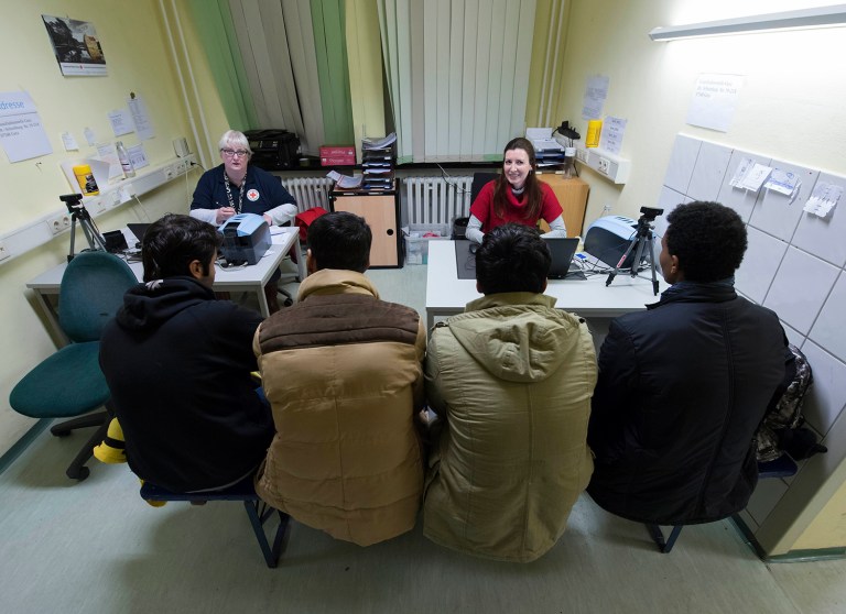 Migrants wait in the registration room at an initial reception center for asylum seekers in Gera, central Germany. A senior German security official told the BBC Thursday that Islamic State 