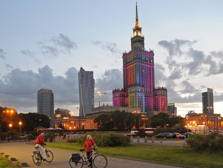 The communist era Palace of Culture, colorfully illuminated, is surrounded by modern skyscrapers, in Warsaw, Poland, Saturday, May 31, 2014. (AP Photo/Alik Keplicz)