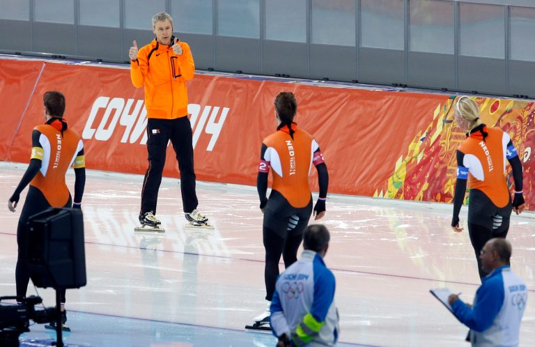 Coach Arie Koops gives two thumbs-up to his riders Sven Kramer, left, Jan Blokhuijsen, center and Koen Verweij, right, after their men's speedskating team pursuit semifinal race at the Adler Arena Skating Center during the 2014 Winter Olympics in Sochi, Russia, Friday, Feb. 21, 2014. (AP Photo/Patrick Semansky)