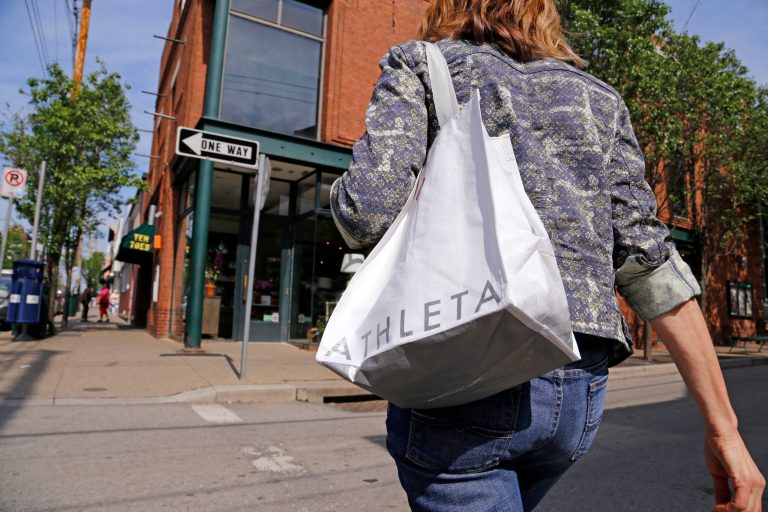 In this photo taken May 14, 2014, Jody Dickman, of Pittsburgh walks in the Shadyside section of Pittsburgh after shopping for a workout outfit at an Athleta store. The private Conference Board reports on consumer confidence for May on Tuesday, May 27, 2014. (AP Photo/Gene J. Puskar)