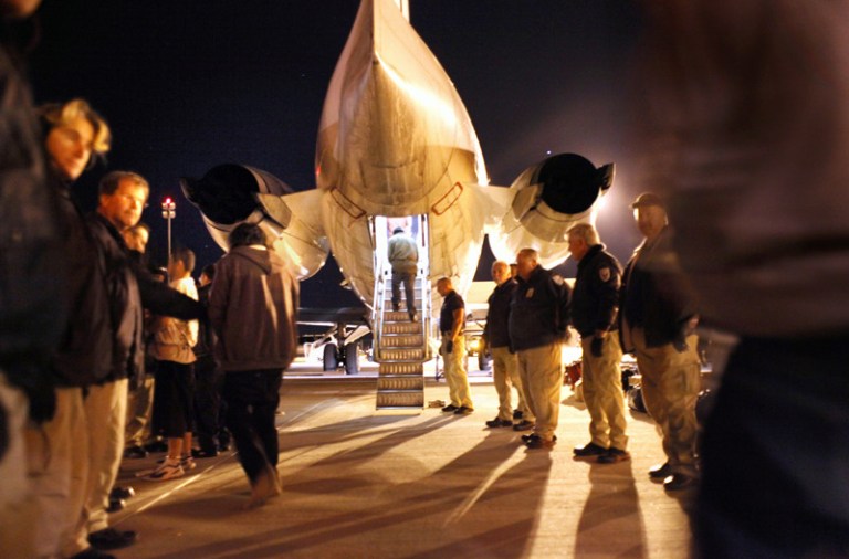 Immigration and Customs Enforcement officers pat down undocumented immigrants from El Salvador before boarding them onto a deportation flight in Mesa, Ariz. (John Moore/Getty Images)