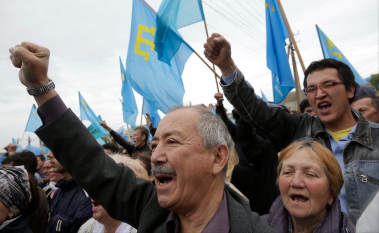 Crimean Tatars chant slogans as they rally in Simferopol, Crimea, Sunday, May 18, 2014. Crimean Tatars gathered for a rally commemorating the 70th anniversary of Stalin's mass deportation. (AP Photo/Max Vetrov)