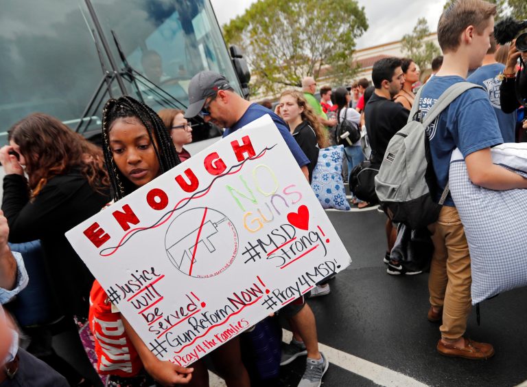 Tyra Hemans, 19, left, and Logan Locke, 17, right, students who survived the shooting at Stoneman Douglas High School, wait to board buses in Parkland, Fla., Tuesday, Feb. 20, 2018. The students plan to hold a rally Wednesday in hopes that it will put pressure on the state's Republican-controlled Legislature to consider a sweeping package of gun-control laws, something some GOP lawmakers said Monday they would consider. (AP Photo/Gerald Herbert)