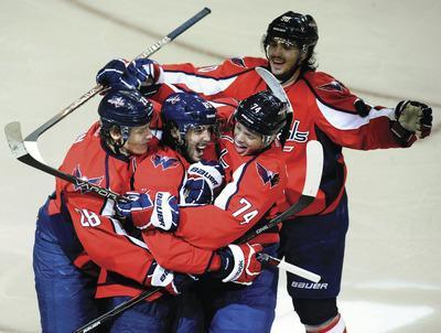 Richard Lipski/AP
Washington's Mathieu Perreault, center, had a hat trick in the Capitals'5-3 win over the Bruins on Tuesday night.