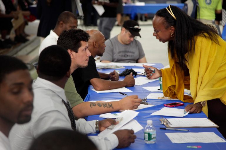 In this this Tuesday, Aug. 21, 2012, photo, job seekers fill out applications at a construction job fair in New York. The number of people seeking unemployment benefits rose a slight 4,000 last week to a seasonally adjusted 372,000, evidence that the job market's recovery remains modest and uneven. (AP Photo/Seth Wenig)