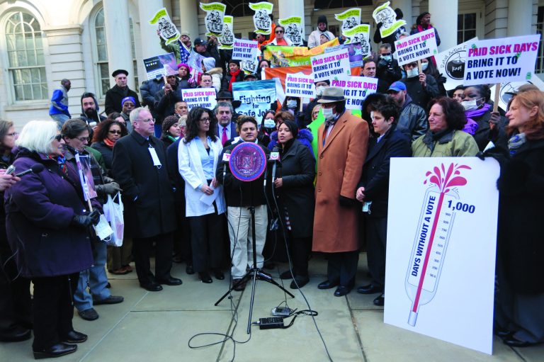 In this Friday, Jan. 18 2013 photo, Emilio Palaguachi, center, speaks during a rally at New York's City Hall to call for immediate action on paid sick days legislation in light of the continued spread of the flu. An unusually early and vigorous flu season is drawing attention to the cause that has both scored victories and hit roadblocks in recent years: mandatory paid sick leave. (AP Photo/Mary Altaffer)