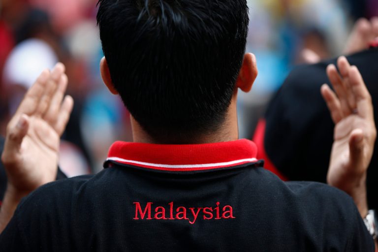 A Muslim man prays during a protest outside the Court of Appeal in Putrajaya, outside Kuala Lumpur, Malaysia, Monday, June 23, 2014. The Federal Court on Monday refused to grant leave to hear the appeal by the Catholic church over the word Allah in its newspaper.  (AP Photo/Vincent Thian)