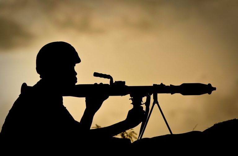 FILE - In this Monday, April 30, 2012 file photo released by the African Union-United Nations Information Support Team (AU-UN IST), a Ugandan soldier serving with the African Union Mission in Somalia (AMISOM) holds a rocket-propelled grenade launcher at sunrise on the frontline near the main road on the northern edge of Maslah Town, the northern city limit of the Somali capital Mogadishu, in Somalia. Some African Union troops in Somalia sexually exploited or raped women and girls who are internal refugees, a new report by an international human rights group alleged Monday, Sept. 8, 2014. (AP Photo/AU-UN IST, Stuart Price, File)