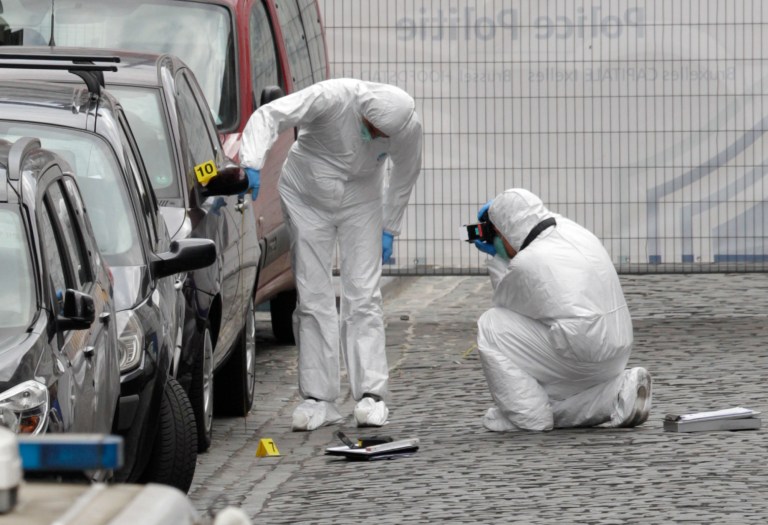 Forensic experts examine the site of a shooting at the Jewish museum in Brussels, Saturday, May 24, 2014. Belgian officials say that at least three people have been killed in gunfire at the Jewish Museum in Brussels. Belgian Foreign Minister Didier Reynders, in a post on Twitter, said he was 