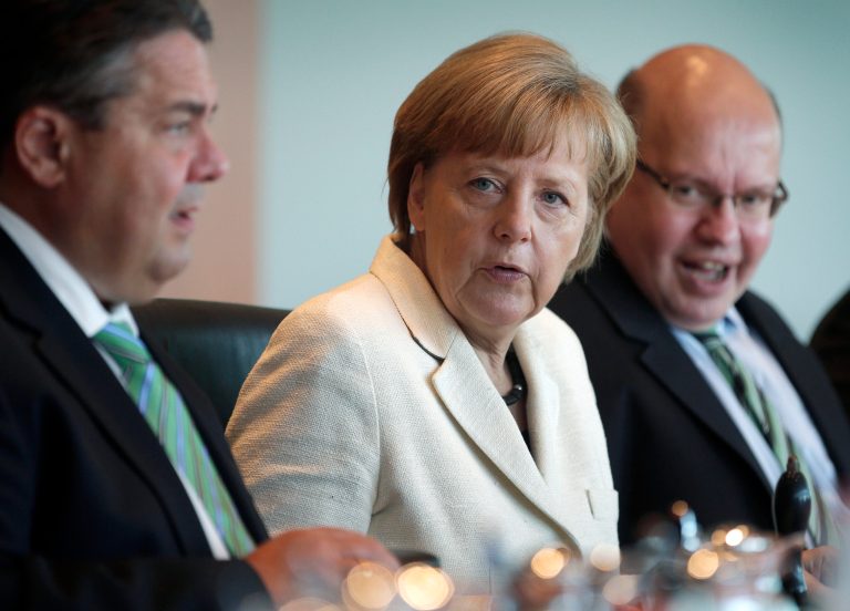 German Chancellor Angela Merkel, center, speaks as she sits between German Economy and Energy Minister Sigmar Gabriel, left, and Peter Altmaier, Head of the Federal Chancellery, right, at the beginning of the weekly cabinet meeting at the chancellery in Berlin, Germany, Wednesday, May 21, 2014. (AP Photo/Michael Sohn)