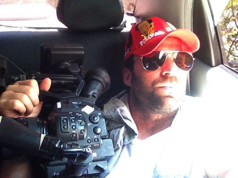 This undated family photo released Thursday, April 25, 2013, shows Timothy Tracy inside of a vehicle in Venezuela. The 35-year-old filmmaker from California was arrested Wednesday, by Venezuelan authorities who are accusing him of fomenting post election violence on behalf of the U.S. government. Friends and family told The Associated Press said that he had been in Venezuela since last year making a documentary about the confrontation between the opposition and a socialist government that is struggling to maintain its once-high popularity after the death of Venezuela's late President Hugo Chavez. (AP Photo/Family courtesy photo)