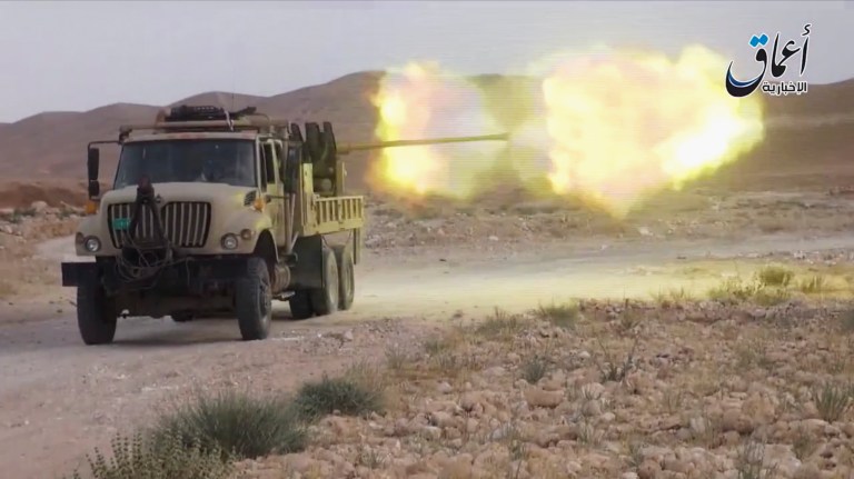 This image made from a militant video posted on YouTube on Tuesday, May 26, 2015, which has been verified and is consistent with other AP reporting, purports to show an armored vehicle of the Islamic State group firing ammunition in Jezel oil fields near Palmyra, Syria. The militant video purportedly showed Islamic State group fighters battling Syrian government forces around the Jezel oil field near Palymra. (Militant video via AP)