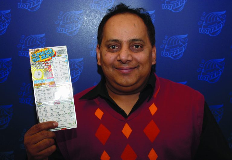 FILE - This undated file photo provided by the Illinois Lottery shows Urooj Khan, 46, of Chicago's West Rogers Park neighborhood, posing with a winning instant lottery ticket. On Friday, Jan 11, 2013, a Cook County judge granted authorities permission to exhume the body of the Chicago lottery winner who was fatally poisoned with cyanide just as he was about to collect his $425,000 payout. His July 20 death was initially ruled a result of natural causes. (AP Photo/Illinois Lottery, File)