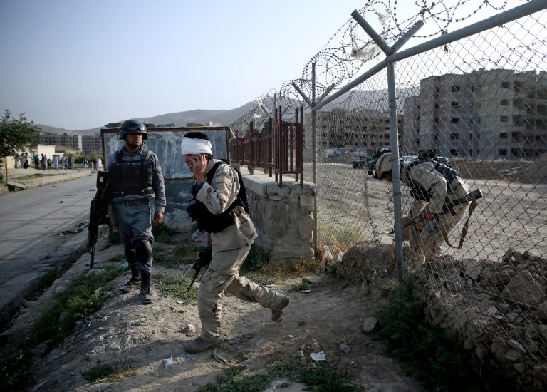A wounded Afghan security personnel speaks on a phone during clashes with Taliban fighters in Kabul, Afghanistan, Thursday, July 17, 2014. Gunmen launched a pre-dawn attack on the Kabul International Airport in the Afghan capital on Thursday, raining down rockets, setting off a gunbattle with security forces and forcing the airport to close for hours, officials said. The militants occupied two buildings which were under construction some 700 meters (yards) north of the facility, and were using them as a base to direct rockets and gunfire toward the airport and international jet fighters flying over Kabul, said Afghan army Gen. Afzal Aman. (AP Photo/Massoud Hossaini)