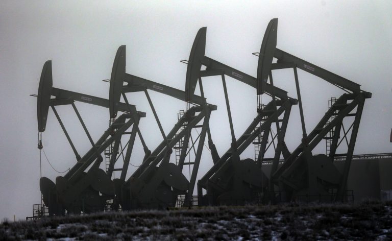 In this Dec. 19, 2014 file photo, oil pump jacks work in unison, in Williston, N.D. (AP Photo/Eric Gay, File)