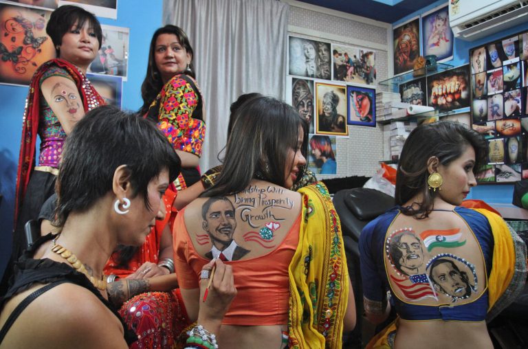 Indian women get their backs painted with portraits of U.S. President Barack Obama and Indian Prime Minister Narendra Modi in Ahmadabad, India, Friday, Sep. 26, 2014. Modi left for his five-day visit to the United States, starting Friday during which he will address the U.N. General Assembly, hold talks with Obama and a slew of top American officials, interact with the heads of major U.S. companies and influential Indian-Americans. (AP Photo/Ajit Solanki)