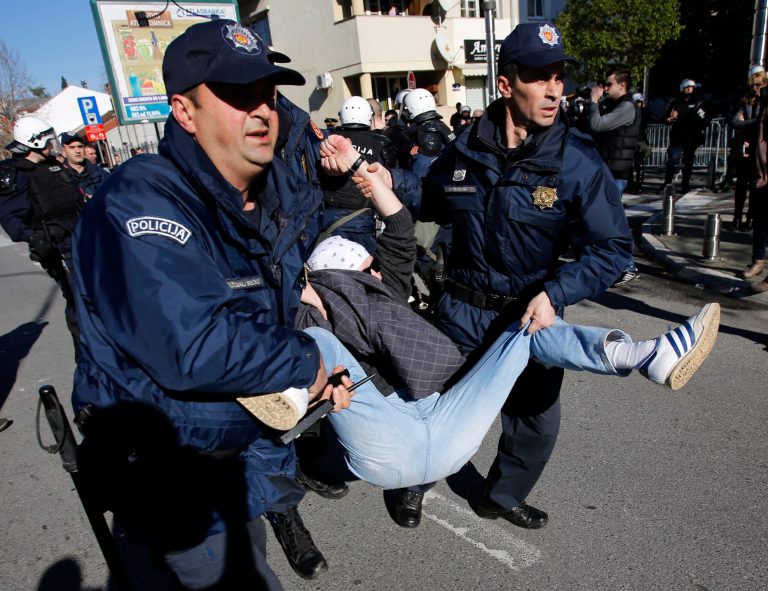 Montenegro police officers arrest a demonstrator during a protest in Podgorica, Montenegro, Saturday, Feb. 15, 2014. The demonstrators who assembled in the downtown area of the capital, Podgorica, on Saturday demanded the resignation of the government of the long-standing prime minister, Milo Djukanovic. They accuse his government of rampant corruption, unemployment and economic mismanagement. (AP Photo/Darko Vojinovic)