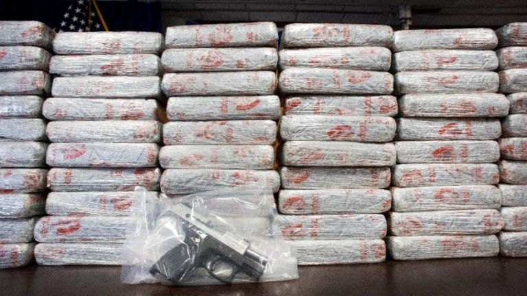 A pistol and 154 pounds of heroin worth at least $50 million are displayed at a Drug Enforcement Administration news conference, Tuesday, May 19, 2015 in New York. AP Photo