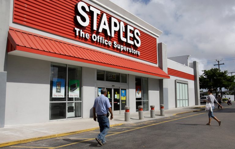 This March 6, 2013 file photo shows a Staples office supply store Miami. The opening of Postal Service retail centers in dozens of Staples stores around the country is being met with threats of protests and boycotts by the agencyâs unions. The new outlets are staffed by Staples employees, not postal workers, and labor officials say that move replaces good-paying union jobs with low-wage, nonunion workers. (AP Photo/ Lynne Sladky, File)