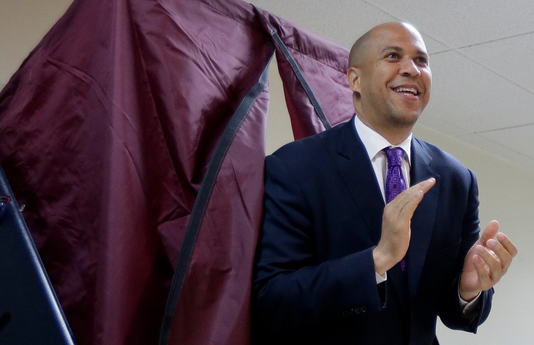 Newark Mayor Cory Booker walks out of a polling booth after casting his vote in a special election for the vacant New Jersey seat in the U.S. Senate, Wednesday, Oct. 16, 2013, in Newark, N.J. Booker is going up against Republican Steve Lonegan. (AP Photo/Julio Cortez)