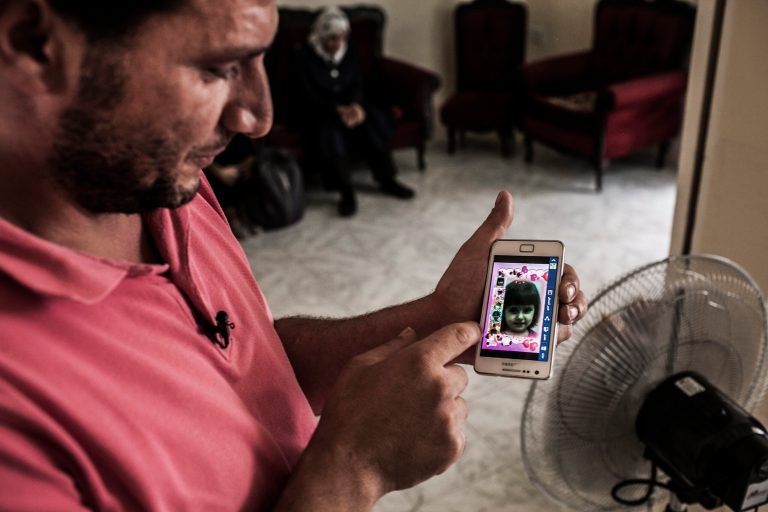 In this image made available from the UNHCR on Monday Sept. 15, 2014 a Syrian refugee  in Valetta Saturday Sept. 13, 2014  shows an image of his young daughter who drowned while the vessel on which they fled their war torn country sank in the Mediterranean sea . The couple lost all of their three children in the accident. Since the start of 2014, more than 2,500 asylum seekers have perished trying to cross the Mediterranean. (AP Photo/Pete Muller/Prime for UNHCR)