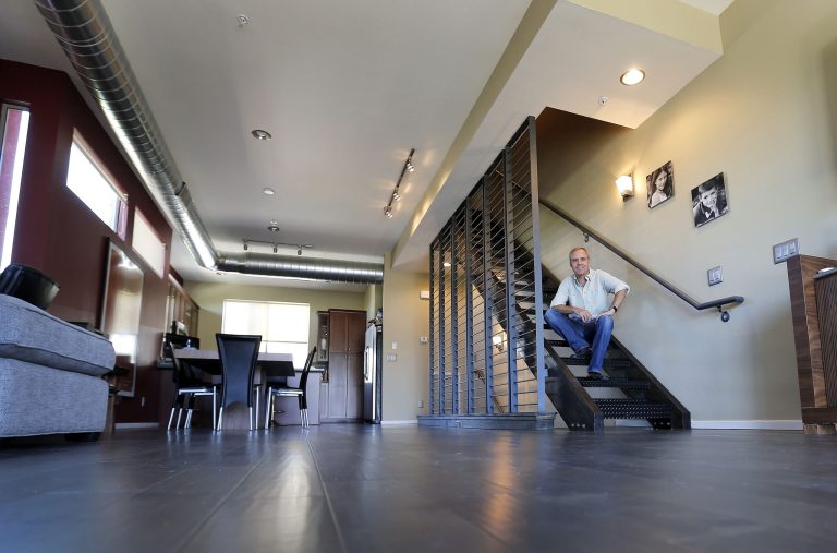 In this June 4, 2014 photo, attorney Tim Nelson poses for photos in his new town home in Phoenix. Americans like Nelson increasingly say they prefer to live near the centers of cities and towns, where commutes tend to be easier and culture, restaurants and entertainment close by. It marks a pronounced shift away from the yearning for open suburban space that drove U.S. home construction for decades. (AP Photo/Matt York)