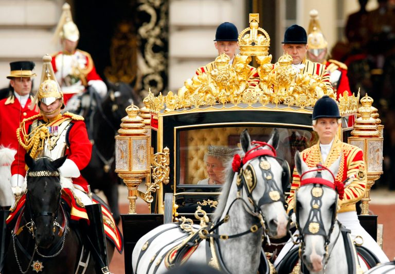 Queen Elizabeth II, centre, and The Duke of Edinburgh leaves Buckingham Palace, riding inside the new Diamond Jubilee State Coach, to deliver her speech at the Palace of Westminster, in London, Wednesday, June 4, 2014.  The Coach was built in Australia by a team of craftsmen led by Jim Frecklington who conceived the initial idea.  The State Opening of Parliament is an annual pageant of pomp and politics centered on the Queen's Speech, a legislative program written by the government but read out by the monarch before a crowd of lawmakers. (AP Photo/Jonathan Brady, Pool)