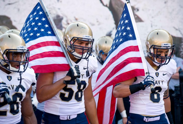   FILE - In this Sept. 7, 2013, file photo, from left, Navy's Marcus Thomas (26), Evan Palelei (58) and Wave Ryder (8) head onto the field at the start of an NCAA college football game against Indiana in Bloomington, Ind. The Defense Department said Tuesday, Oct. 1, 2013, that it has temporarily suspended all sports competitions at the service academies as a result of the partial government shutdown. The decision jeopardizes this weekend's football games , Air Force at Navy and Army at Boston College. (AP Photo/Doug McSchooler, File)  