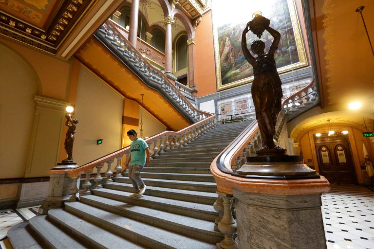 In this July 1, 2014 photo, Briana Chick, of Aurora, Ill., walk down the recently renovated main stairway leading up to the third floor of the Senate and House chambers at the state Capitol in Springfield, Ill. Illinois Gov. Pat Quinn's veto of future state capitol renovations may spur talk of an override among lawmakers who championed the rare upgrade for the statehouse. (AP Photo/Seth Perlman)
