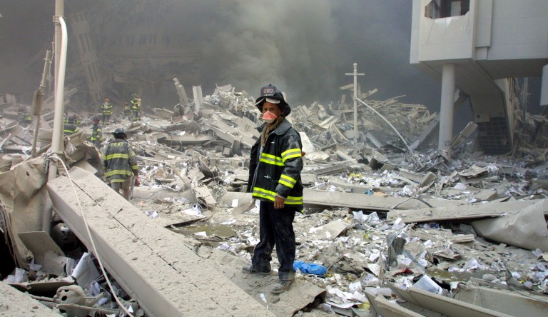 Firefighters walk through the rubble in the aftermath of the September 11 attacks.