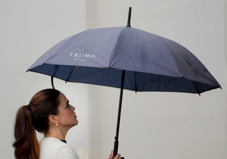 An unidentified guest uses a Trump Hotel branded umbrella as she walks into the West Wing of the White House in Washington, Friday, March 31, 2017. (AP Photo/Pablo Martinez Monsivais)