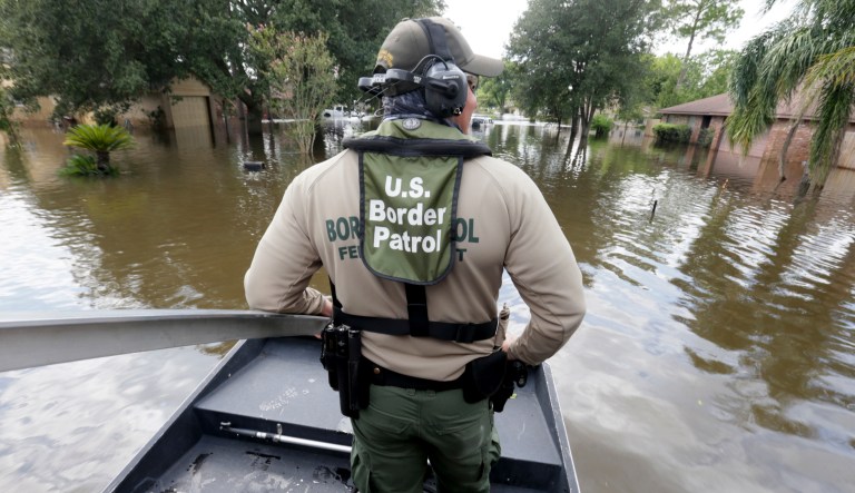 U.S. Border Patrol Agent Steven Blackburn looks out while standing on the bow of an air boat during a search a rescue operation in a neighborhood inundated by floodwaters from Harvey in Houston on Wednesday. 