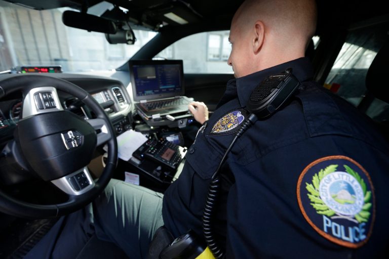 In this photo taken Jan. 16, 2013, Little Rock Police Officer Grant Humphries loos at a computer monitor connected to a camera mounted near the rear window of his patrol car in Little Rock, Ark. The device is part of a system that scans traffic on the streets, relaying the data it collects to the computer for sifting. Police say the surveillance helps identify stolen cars and drivers with outstanding arrest warrants. (AP Photo/Danny Johnston)