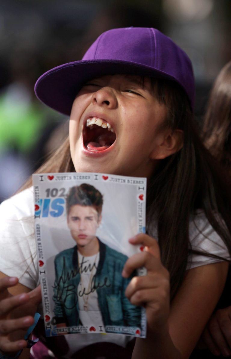   A fan of pop star Justin Bieber cheers outside a hotel where Bieber gave a news conference in Mexico City, Monday, June 11, 2012. Bieber will perform in a free open-air concert tonight at the Mexico City's main historic plaza, the Zocalo. (AP Photo/Alexandre Meneghini)  