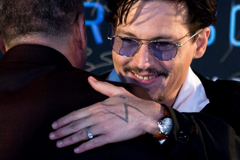Actor Johnny Depp, with a diamond ring on his left hand, attends a promotional event for his new movie âTranscendenceâ in Beijing, China, Monday, March 31, 2014.  Johnny Depp showed off a diamond engagement ring that he called a âchickâs ringâ on Monday, indirectly confirming rumors of his engagement to actress Amber Heard. (AP Photo/Alexander F. Yuan)