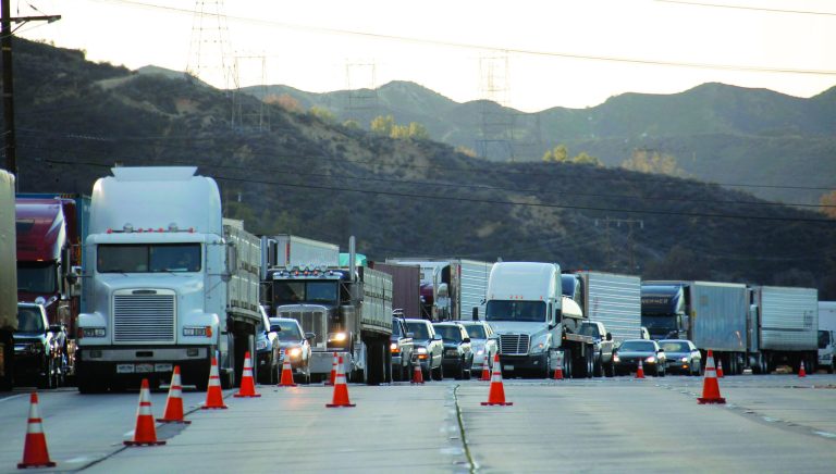 Trucks backed up along Interstate 5 north of Los Angeles on Friday, Jan. 11, 2013. The California Highway Patrol has partially reopened a 40-mile stretch of Interstate 5 north of Los Angeles that was closed for many hours due to snow. The CHP began escorting southbound motorists through the high mountain pass Friday morning. Northbound lanes are still closed. (AP Photo/Nick Ut)