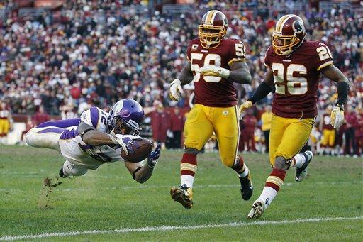 Minnesota Vikings wide receiver Percy Harvin (12) dives for a touchdown as Washington Redskins inside linebacker London Fletcher (59) and cornerback Josh Wilson (26) chase him into the end zone during the second half of an NFL football game against Washington Redskins in Landover, Md., Saturday, Dec. 24, 2011. 